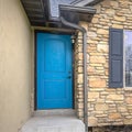 Square frame Home with stairs blue front door stone wall and windows with wooden shutters Royalty Free Stock Photo