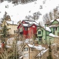 Square frame Homes built on the slope of a mountain blanketed with snow during winter