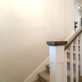 Square frame Indoor staircase of a home with white balusters brown handrail and newel