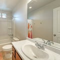 Square frame Interior of a white bathroom with shower tub combo and single vanity sink with mirror Royalty Free Stock Photo