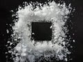 Square frame lies in the middle of white snow against black background