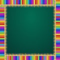 Square frame made of colorful rainbow pencils on green blackboard background