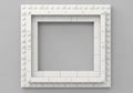 Square frame made of interlocking white plastic bricks resembling LEGO pieces, set against a gray Royalty Free Stock Photo