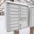 Square frame Mailbox against neighbourhood landscape covered with fresh white snow in winter