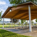 Square frame Picnic tables and benches under a pavilion on a scenic park on a sunny day Royalty Free Stock Photo