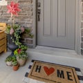 Square frame Porch of a home decorated with wooden chair potted plants wreath and doormat