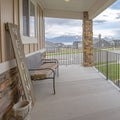 Square frame Porch overlooking yard road homes lake and mountain under cloudy blue sky