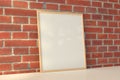 Square frame poster mock up on the white table with red brick wall on background Royalty Free Stock Photo