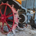 Square frame Red wheel rim of an and vintage tractor against stone wall of a farm barn Royalty Free Stock Photo