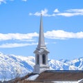 Square frame Rooftop of church with a modern spire design against snowy mountain and lake Royalty Free Stock Photo