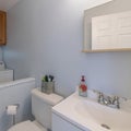 Square frame Small bathroom and laundry combo interior with sink and wooden cabinet Royalty Free Stock Photo