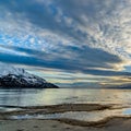 Square frame Striking cloudy sky over a calm lake that reflects the golden sun at sunset