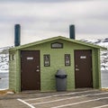 Square frame Unisex public restroom against lake snowy mountain and cloudy sky in winter Royalty Free Stock Photo