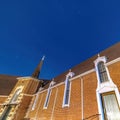 Square frame Vivid blue sky over a church in Provo Utah with brick wall and arched windows