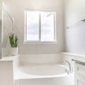 Square frame White bathroom with tub, shower stall with glass and vanity cabinet with marble top, sink and mirror Royalty Free Stock Photo