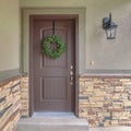 Square Front door of suburban home with green wreath