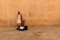 Valletta, Malta, August 2019. A girl with a violin is preparing for a concert near the old fortress wall.