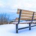 Square Frosted bench on snowy hill with Utah Lake and overcast sky view in winter