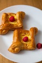 square fruit filled French puff pastry dessert with berries on a wooden background