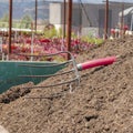 Square Garden soil with rake on top in a green metal tray Royalty Free Stock Photo