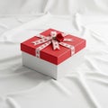 Square gift box with a red lid and white base resting on a white fabric Royalty Free Stock Photo
