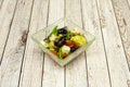 Square glass bowl with Greek salad of black olives, cucumbers, peppers, red onion Royalty Free Stock Photo