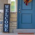 Square Golden wreath on the blue front door of a house with concrete and stone wall