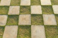 A square of green grass and white concrete patio stones square in outdoor decoration, Grass checkered floor Royalty Free Stock Photo