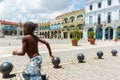 Square in Havana surround by colonial style buildings with boy running past blurred in motion