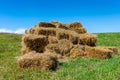 Square hay bales on green meadow with blue sky Royalty Free Stock Photo