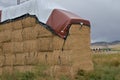 Square hay bales stacked and under protective tarpaulin Royalty Free Stock Photo