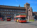 A square in the historical centre of Riga, the capital of Latvia, red touristic coaches and a monument