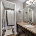 Square Home bathroom with gray wall brown wooden cabinet and marble countertop Royalty Free Stock Photo