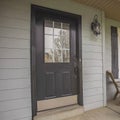 Square Home with furniture on the small porch in front of window with wooden shutters