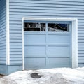 Square Home with grayish blue wall attached garage and stairs leading to the entrance