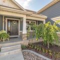 Square Home with landscaped yard stairs porch and front door with sidelight and wreath