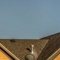 Square House exterior with roof shingles and round gable window against blue sky Royalty Free Stock Photo