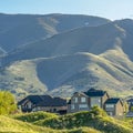 Square Houses at the base of a mountain under bright sky on a sunny day