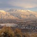 Square Houses beneath scenic Mount Timpanogos with cloudy blue sky overhead in winter