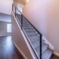 Square Indoor staircase against brown wooden floor and plain white wall of home