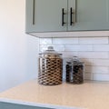 Square Jars of cookies on kitchen counter top against tile backsplash and white wall Royalty Free Stock Photo