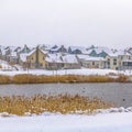 Square Lake with grassy and snow blanketed shore on a cloudy winter day