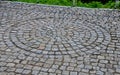 Square with a large dark gray circle inside a small round of cobblestone cubes. the stone is granite and basalt. a court of honor