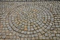 Square with a large dark gray circle inside a small round of cobblestone cubes. the stone is granite and basalt. a court of honor