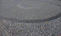 Square with a large dark gray circle inside a small round of cobblestone cubes. the stone is granite and basalt. a court of honor Royalty Free Stock Photo