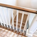 Square Looking down on U shaped indoor staircase with white baluster and brown handrail