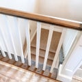 Square Looking down on U shaped indoor staircase with white baluster and brown handrail Royalty Free Stock Photo