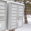 Square Mailbox against neighbourhood landscape covered with fresh white snow in winter