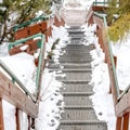 Square Metal grate tread stairs on snowy hill going down to a road viewed in winter Royalty Free Stock Photo