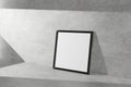 Square mock-up picture frame in black stend on a concrete floor simple interior bright room light and shadow of the window. 3D Royalty Free Stock Photo